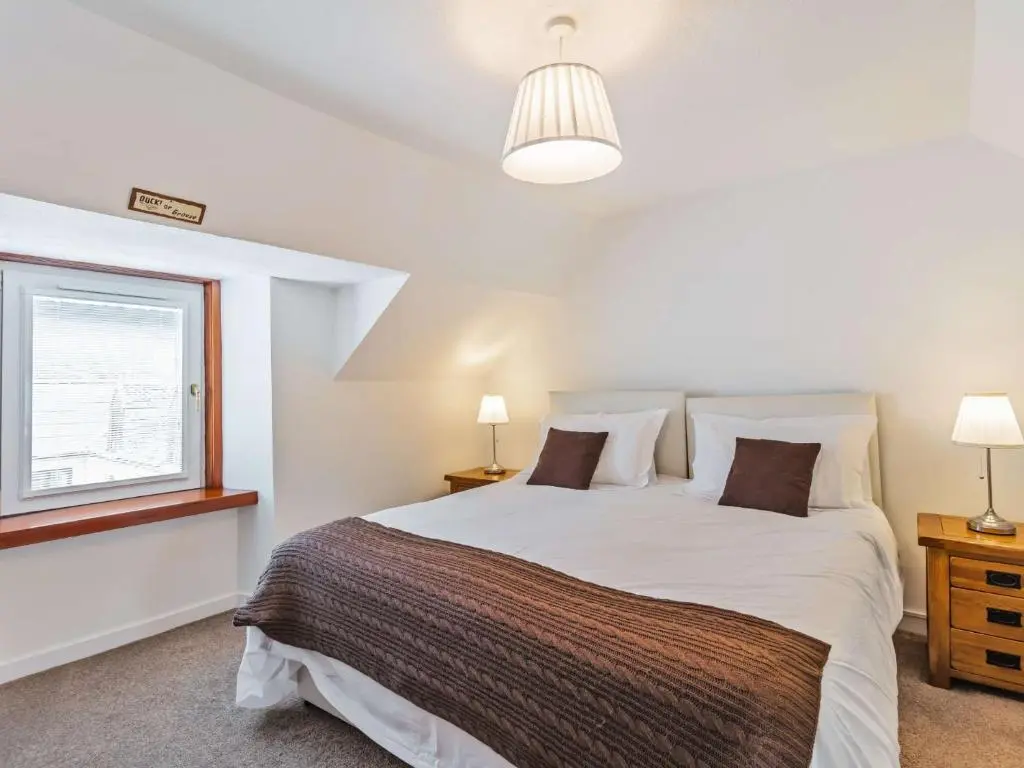 a bedroom with a large bed and a window at 4 Bed in Tomintoul 46162 in Tomintoul
