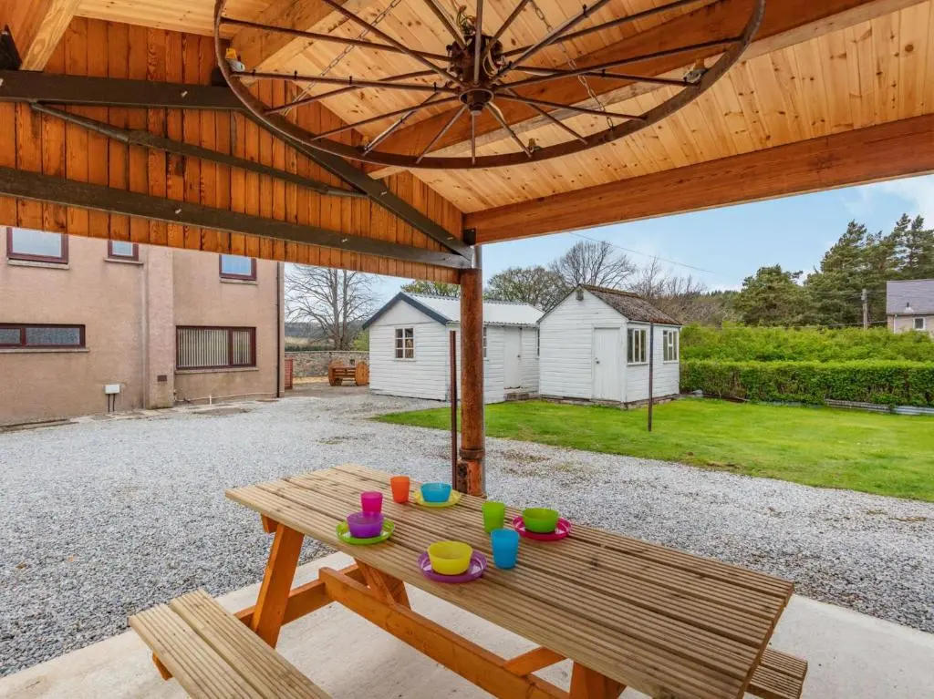 a wooden picnic table under a wooden umbrella at 4 Bed in Tomintoul 46162 in Tomintoul