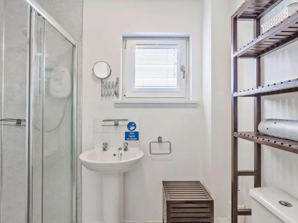 a white bathroom with a sink and a shower at 4 Bed in Tomintoul 46162 in Tomintoul