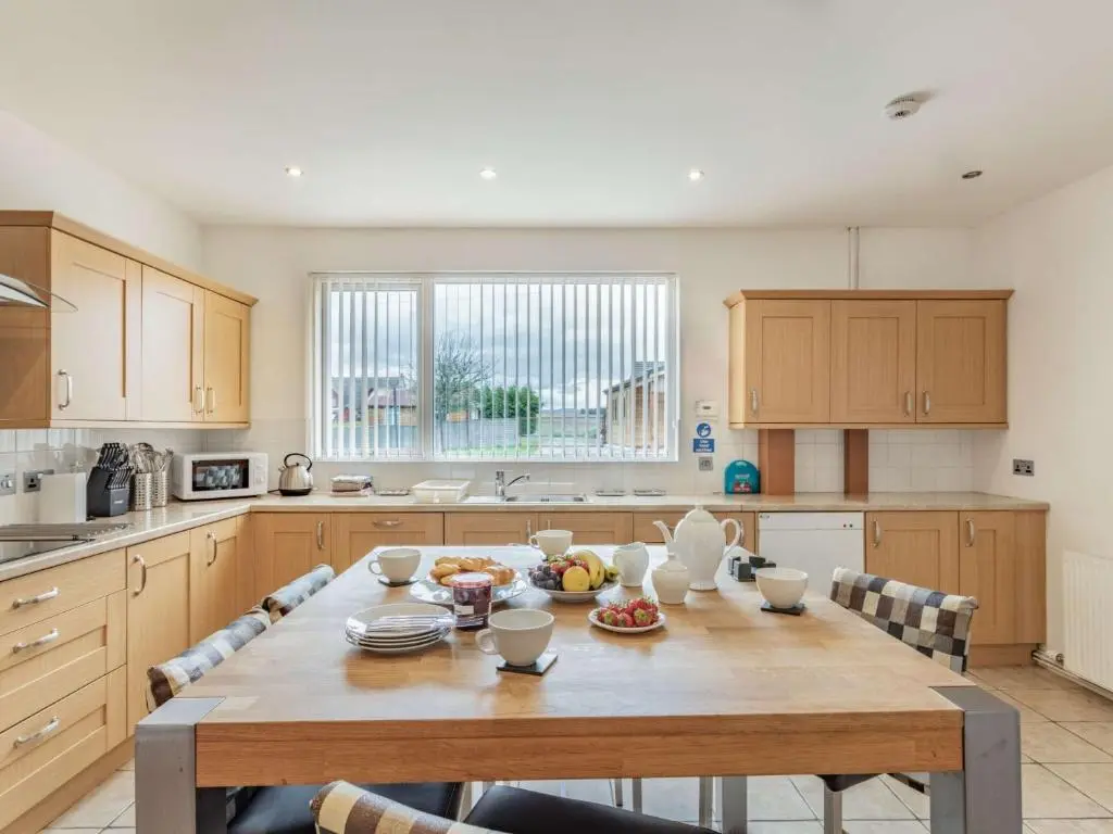 a kitchen with a large wooden table with chairs at 4 Bed in Tomintoul 46162 in Tomintoul