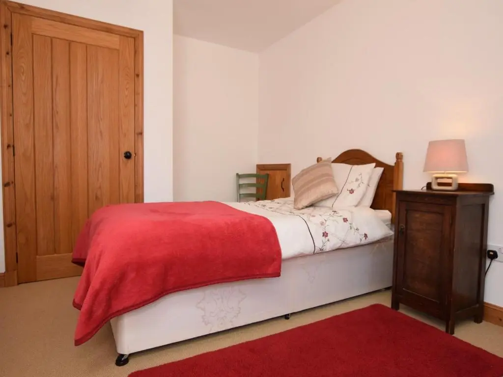 a bedroom with a bed with a red blanket at 3 Bed in Huntly 57368 in Insch