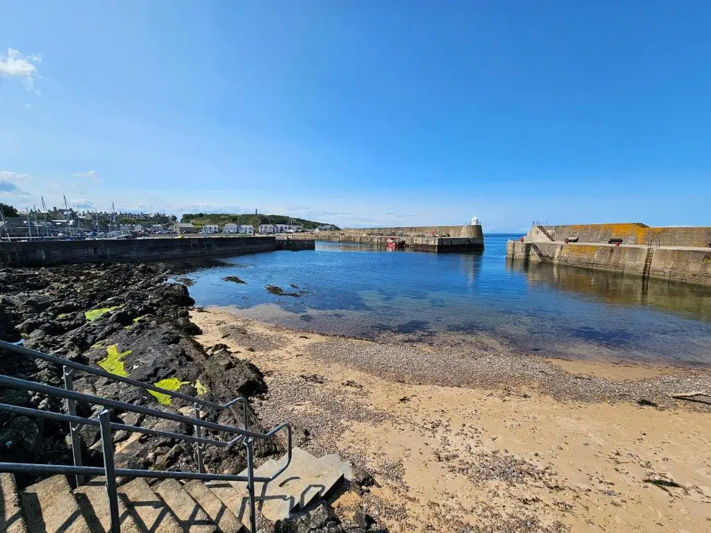 a beach with a pier and the water at 2 Bed in Findochty 76557 in Findochty