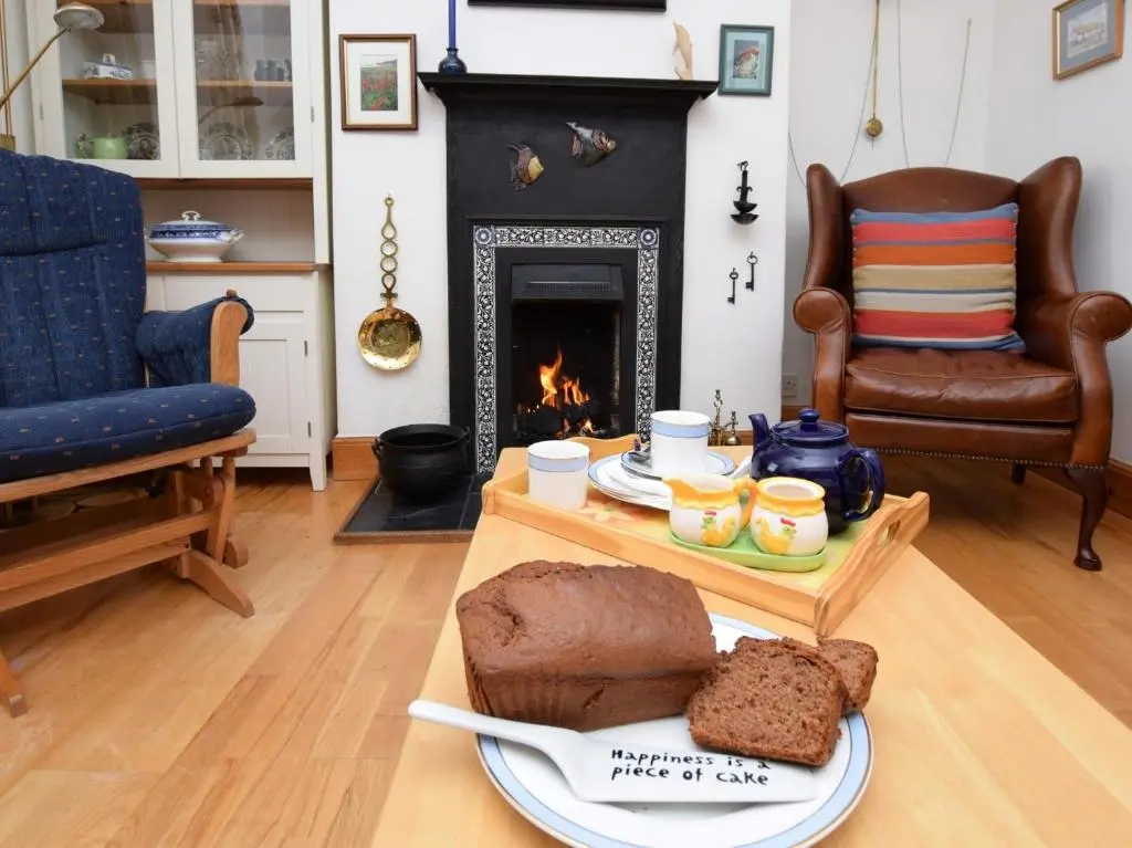 a living room with a table with bread and a fireplace at 2 Bed in Findochty 76557 in Findochty