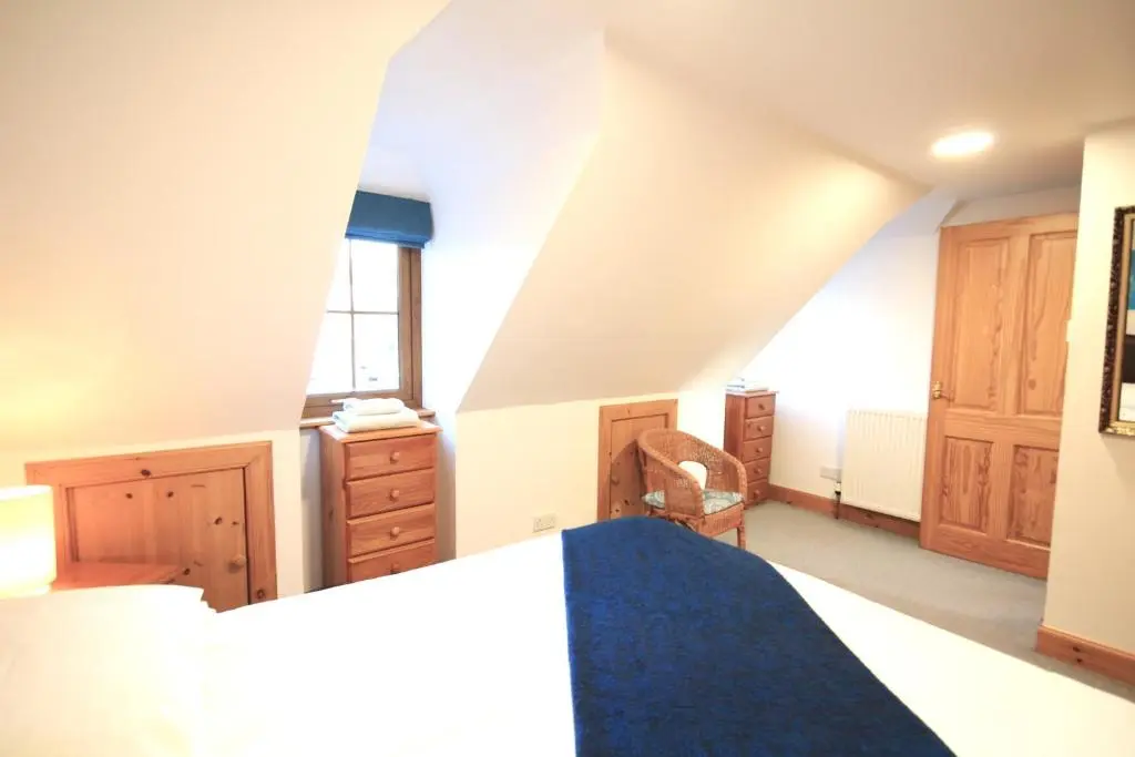 a bedroom with a bed and a dresser at 23 Fairfield in Inverness