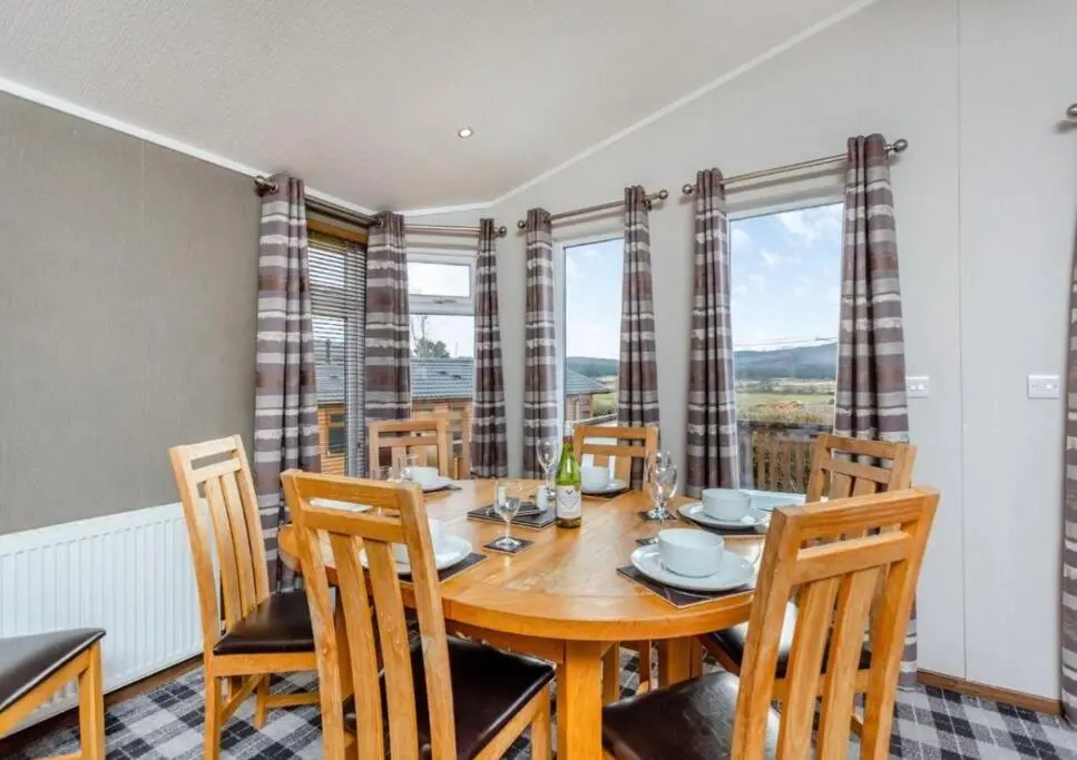 a dining room with a wooden table and chairs at Scottish retreat in Banchory