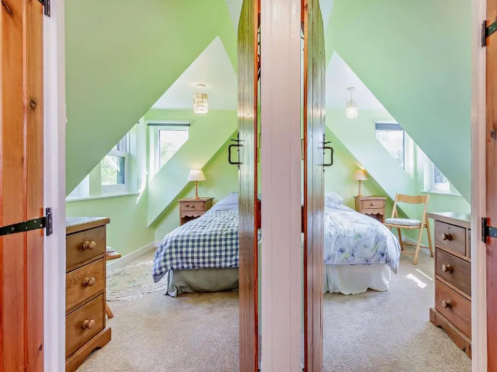 a attic bedroom with two beds and a staircase at 3 Bed in Kildonan SU192 in Helmsdale
