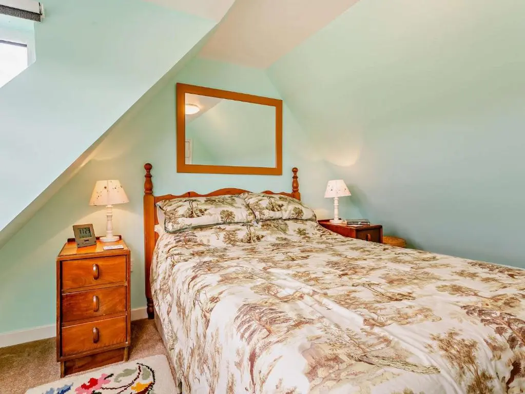 a bedroom with a bed and two night stands with lamps at 3 Bed in Kildonan SU192 in Helmsdale