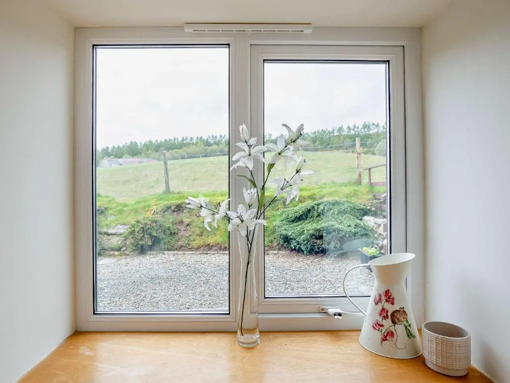 a vase with flowers sitting on a window sill at 1 Bed in Beauly 82778 in Beauly