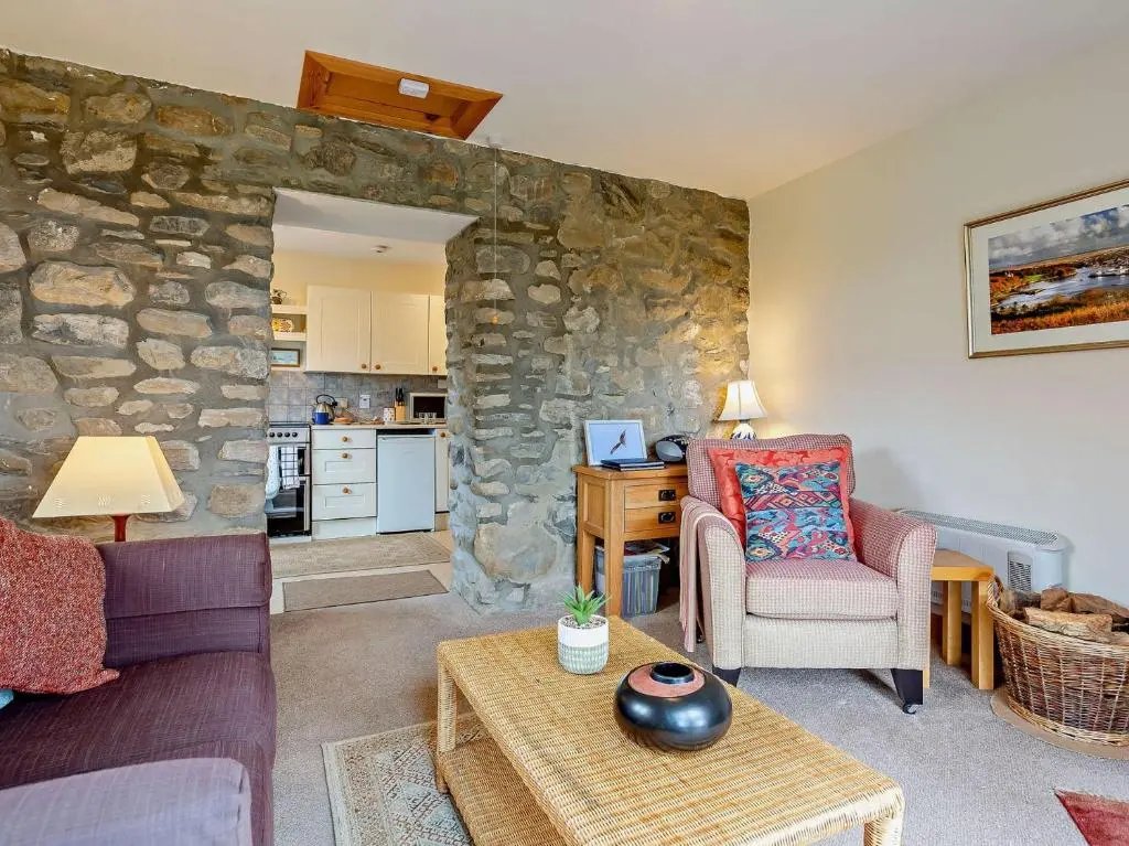 a living room with a stone wall at 1 Bed in Beauly 82778 in Beauly