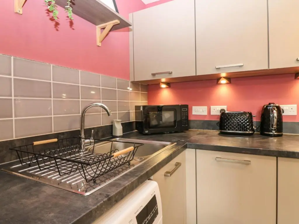 a kitchen with a sink and a microwave at 11 Ambleside Court in Banchory