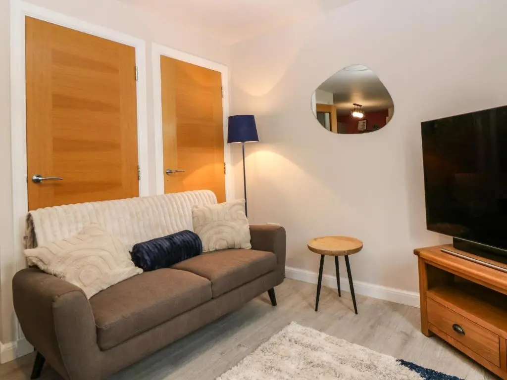 a living room with a couch and a flat screen tv at 11 Ambleside Court in Banchory