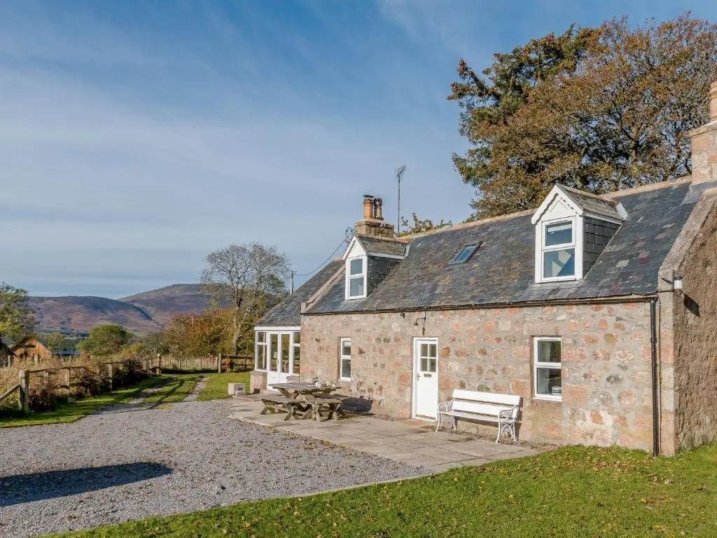 an old stone house with a bench and a table at 3 Bed in Dinnet 53150 in Dinnet