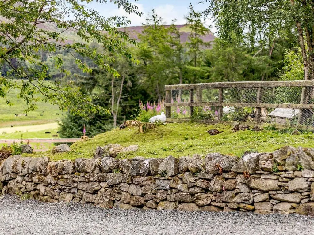 a stone wall in front of a field with a fence at 1 Bed in Blacklunans CA361 in Cray