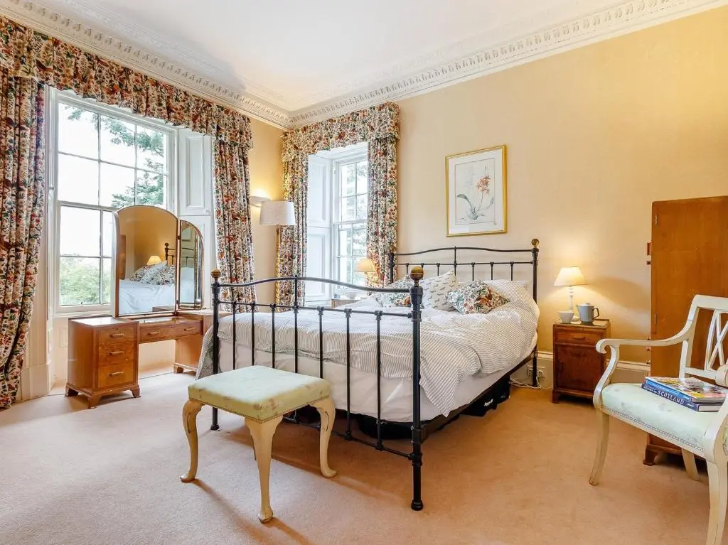 a bedroom with a bed and a chair and windows at 5 Bed in Blacklunans CA409 in Cray