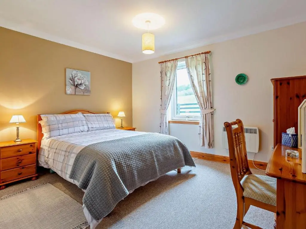 a bedroom with a bed and a desk and a window at 1 Bed in Beauly 82779 in Beauly