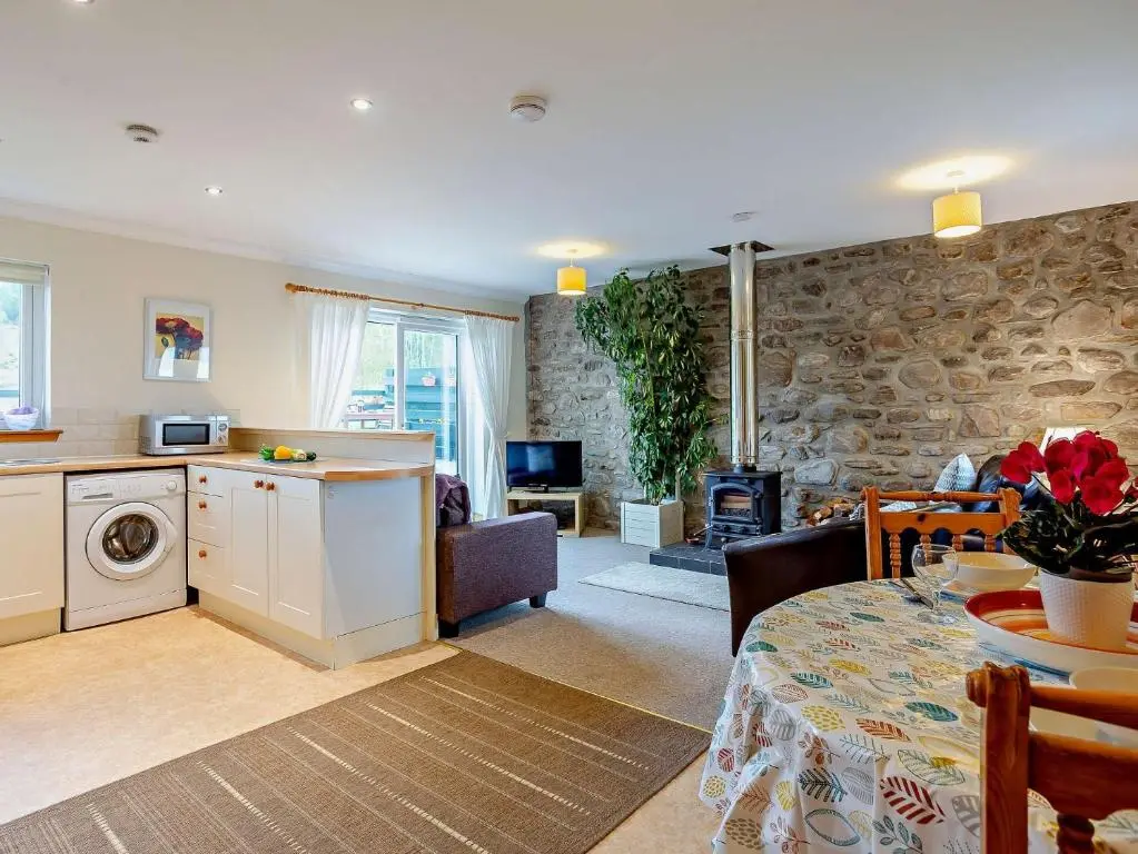a kitchen and living room with a table and a living room at 1 Bed in Beauly 82779 in Beauly