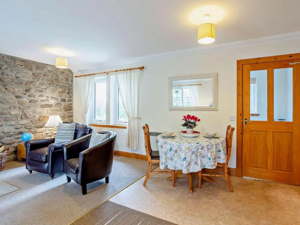a living room with a table and chairs at 1 Bed in Beauly 82779 in Beauly