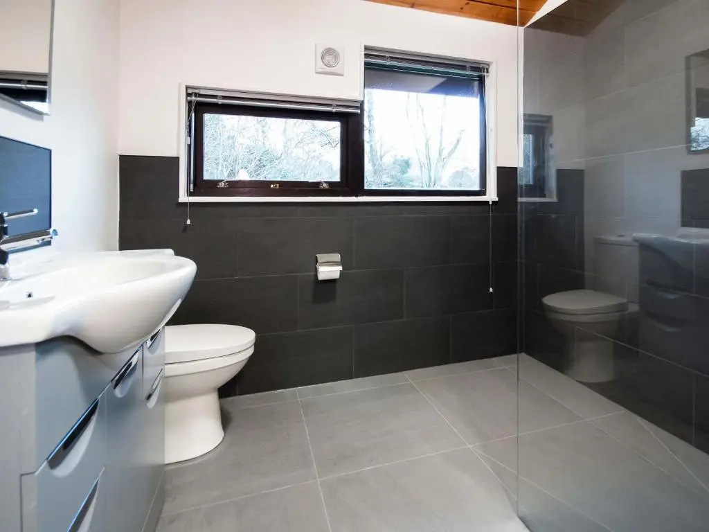 a bathroom with a sink and a toilet and a window at Dornie Lodge in Beauly