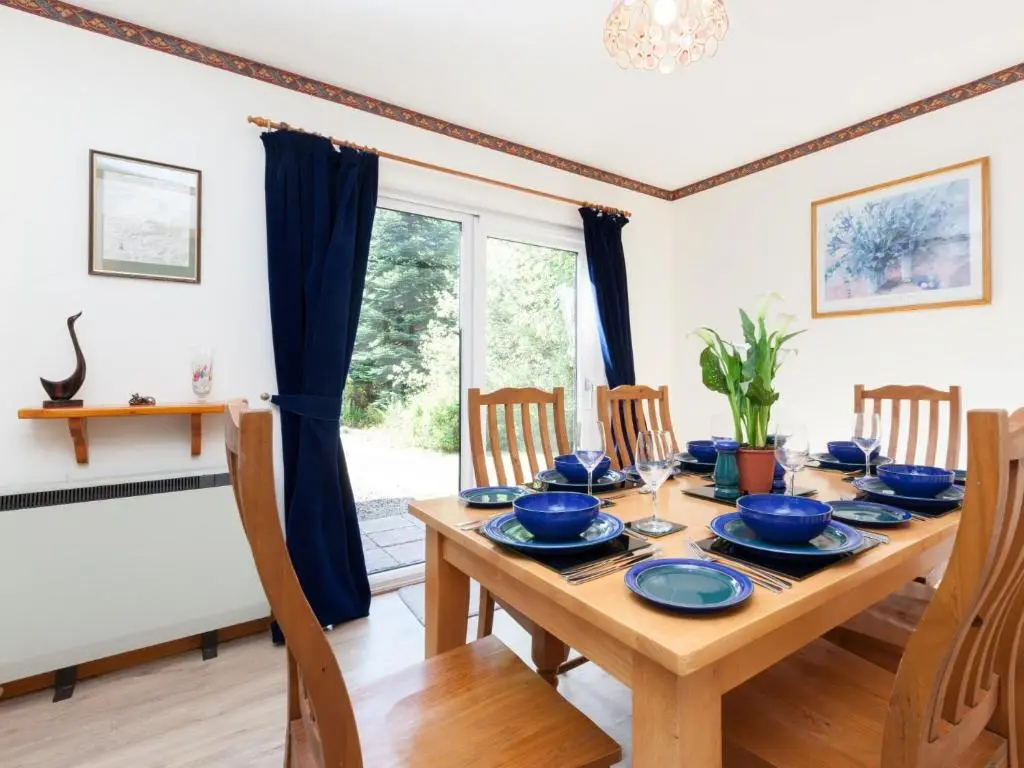 a dining room with a wooden table and chairs at 3 Bed in Drumnadrochit IN633 in Balnain
