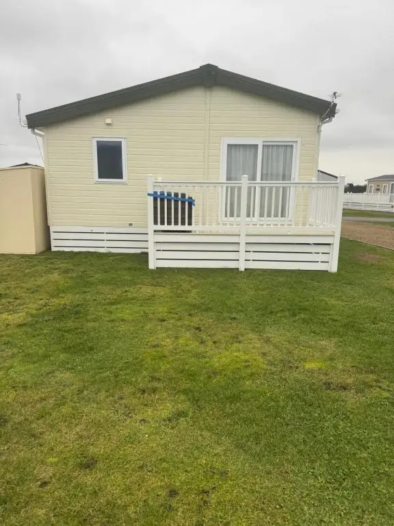 a house with a white fence in a yard at Aurora luxury beach lodge in Lossiemouth