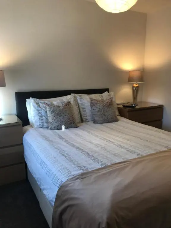 a bedroom with a large bed with white sheets and pillows at Elgin, home from home in Elgin