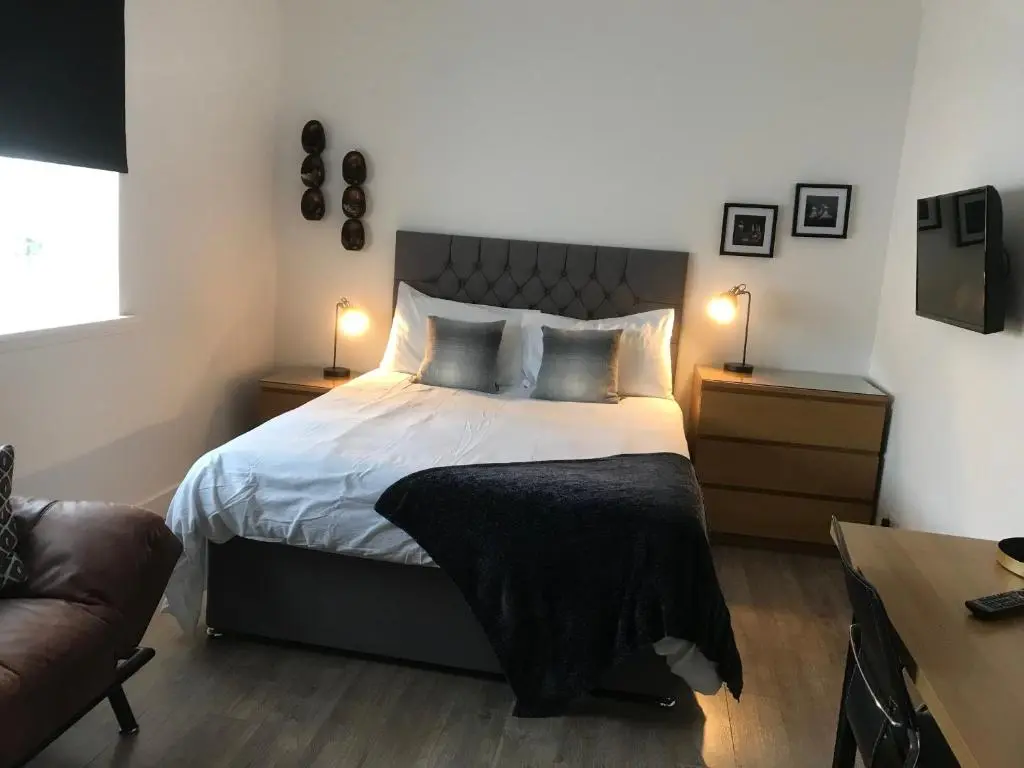 a bedroom with a bed and a couch and two lamps at Elgin, home from home in Elgin