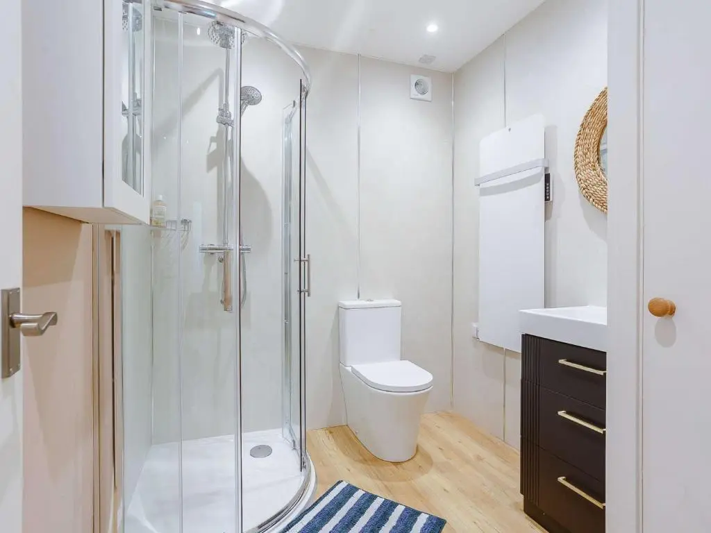 a white bathroom with a shower and a toilet at 1 Bed in Balblair 89058 in Culrain