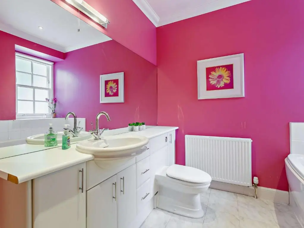 a bathroom with pink walls and a toilet and a sink at 3 Bed in Conon Bridge CA388 in Cononbridge