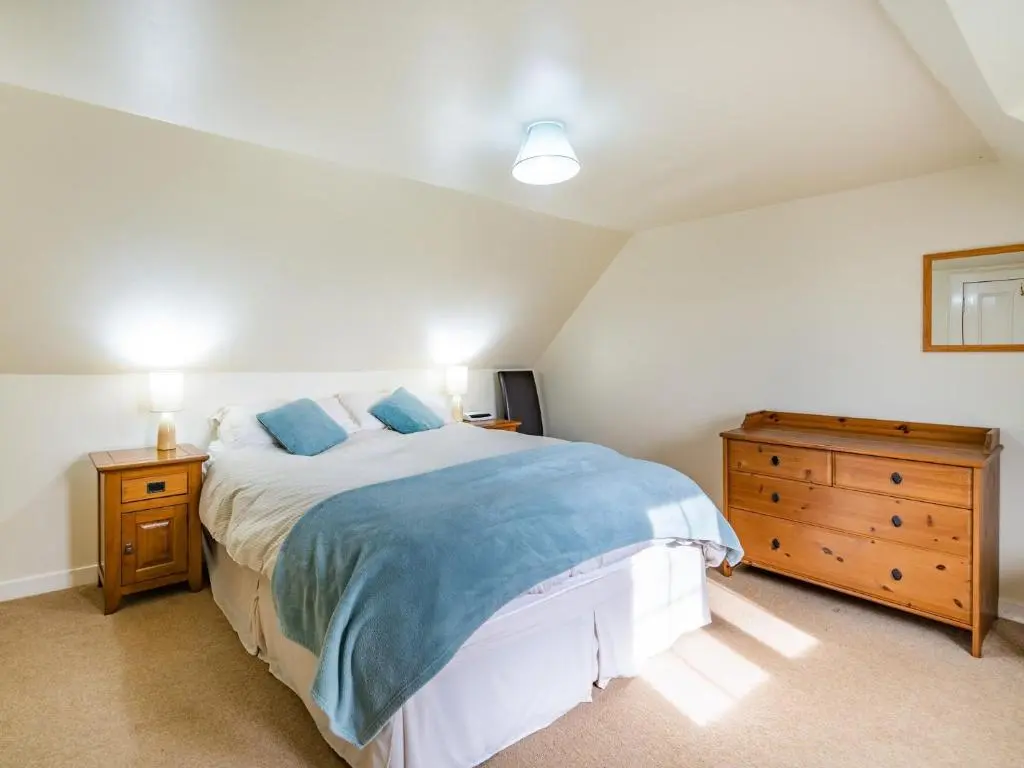 a bedroom with a large bed and a wooden dresser at 3 Bed in Carron CA227 in Carron