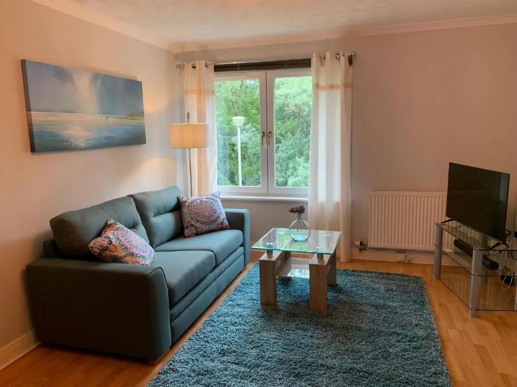 a living room with a couch and a table at Modern One Bedroom Apartment in Lossiemouth