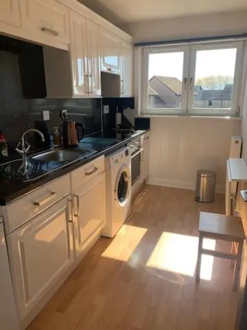 a kitchen with a sink and a washing machine at Modern One Bedroom Apartment in Lossiemouth