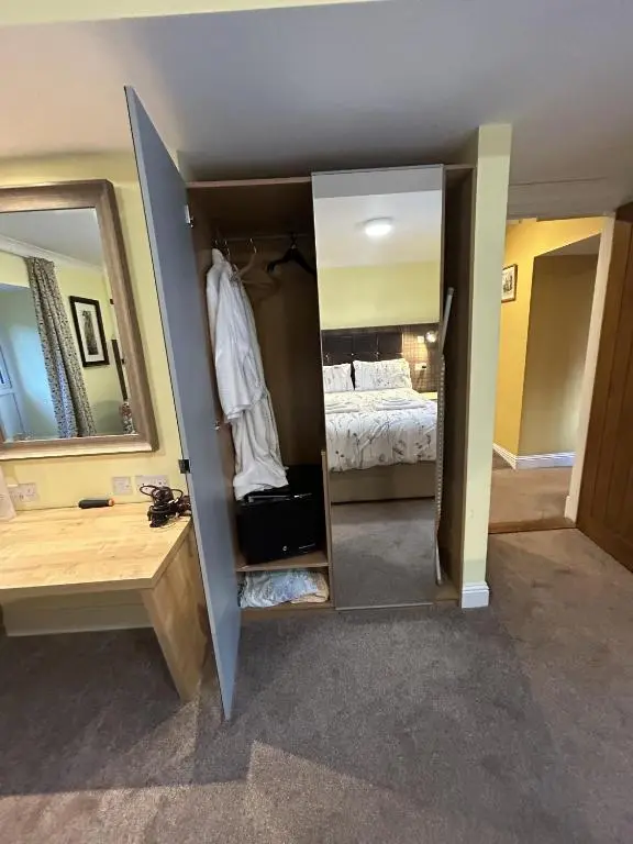 a room with a mirror and a bedroom with a bed at The Secret Garden at Old Drynie House - Self Catering in Inverness