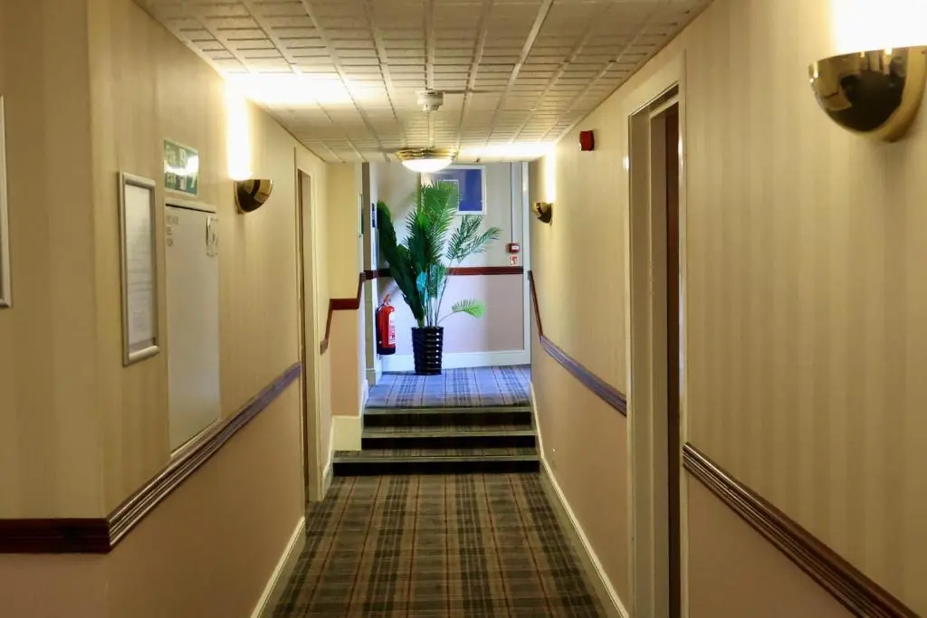 a hallway with stairs with a potted plant at Britannia Hotel Aberdeen in Aberdeen