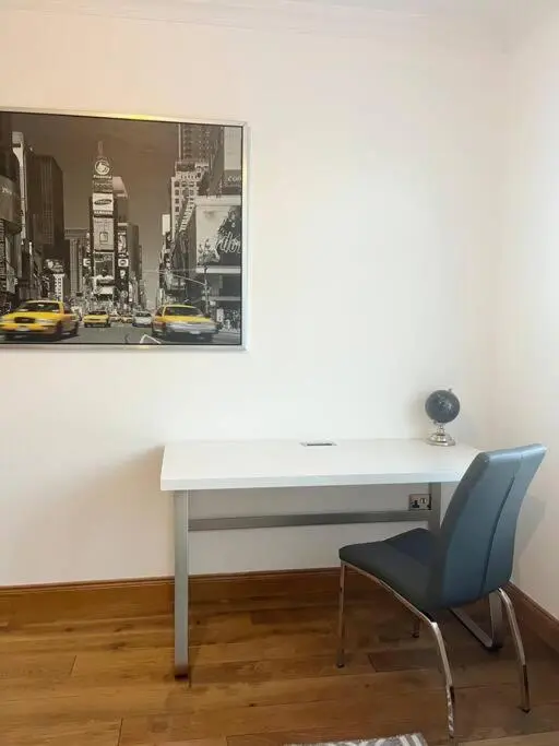 a white desk with a chair and a picture on the wall at BraeView House in Inverness