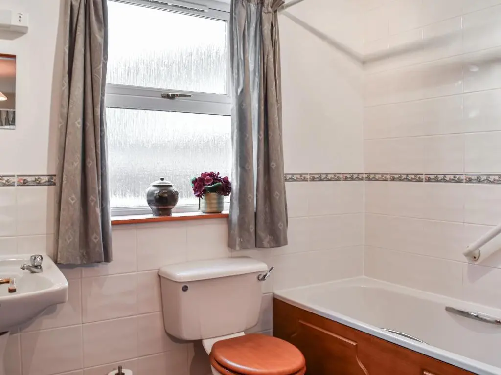 a bathroom with a toilet and a sink and a window at Pine Tree Cottage - Uk45925 in Ballater