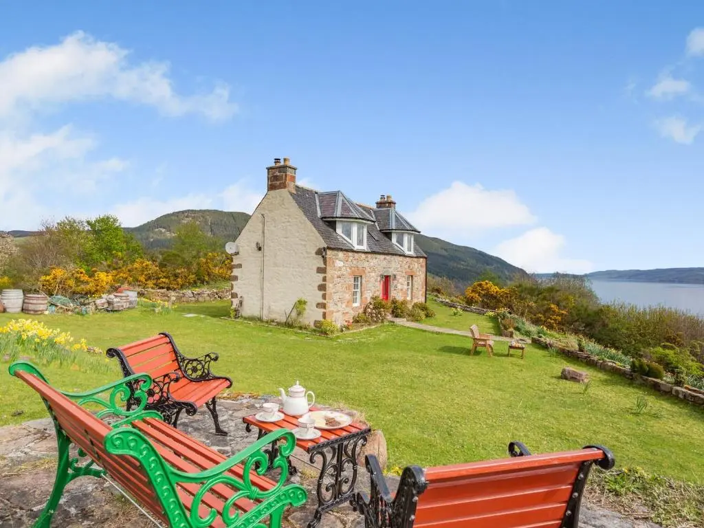two chairs and a table in front of a house at 2 bed in Loch Ness CA315 in Drumnadrochit