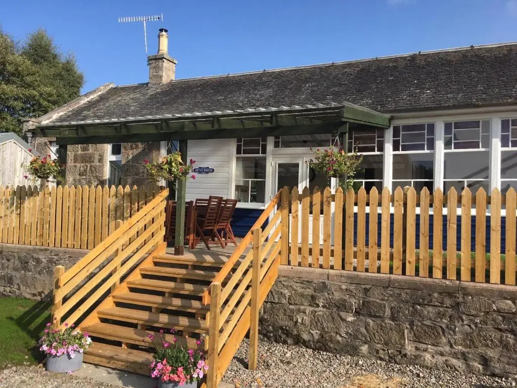 a wooden fence in front of a house at Nethy Station - Seasgair Lodges in Nethy Bridge
