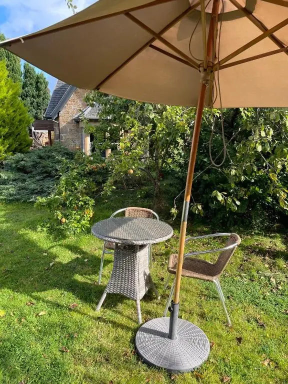 a table and two chairs with an umbrella at Braemorriston Lodge in Elgin
