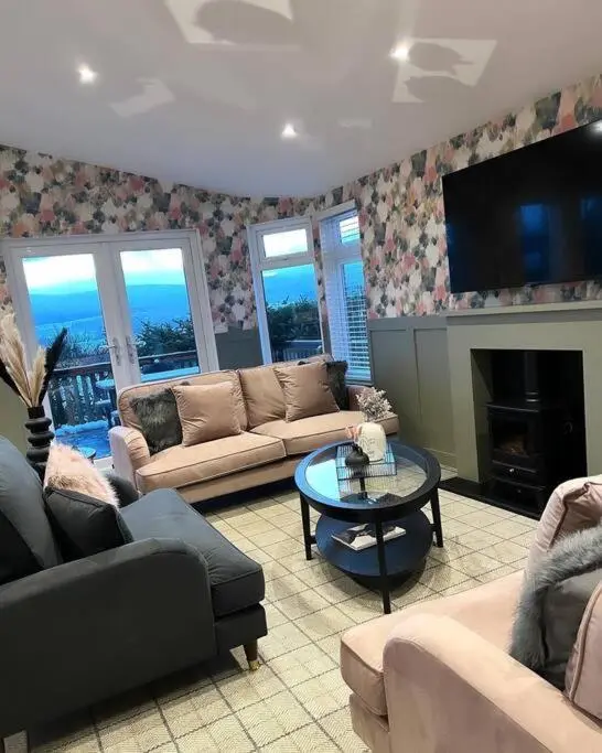 a living room with couches and a table and a tv at Luxury Lodge With Hot Tub In Royal Deeside in Strachan