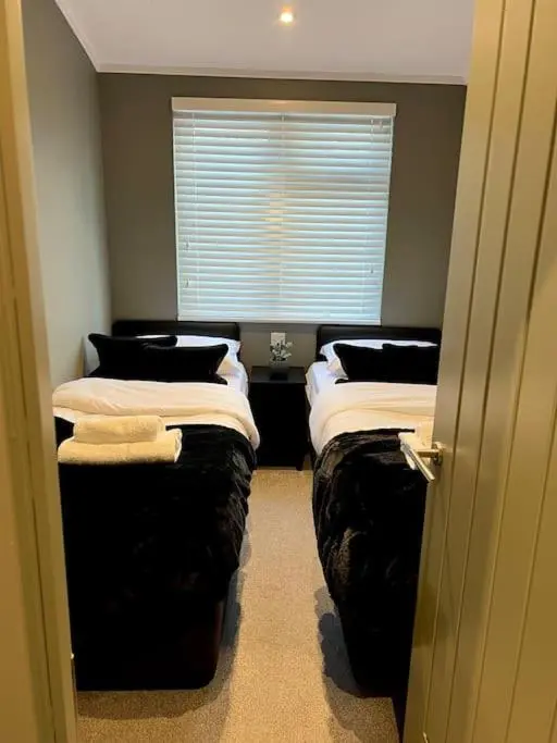 three beds in a room with a window at Luxury Lodge With Hot Tub In Royal Deeside in Strachan