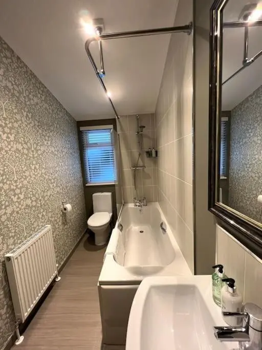 a bathroom with a tub and a toilet and a sink at Luxury Lodge With Hot Tub In Royal Deeside in Strachan