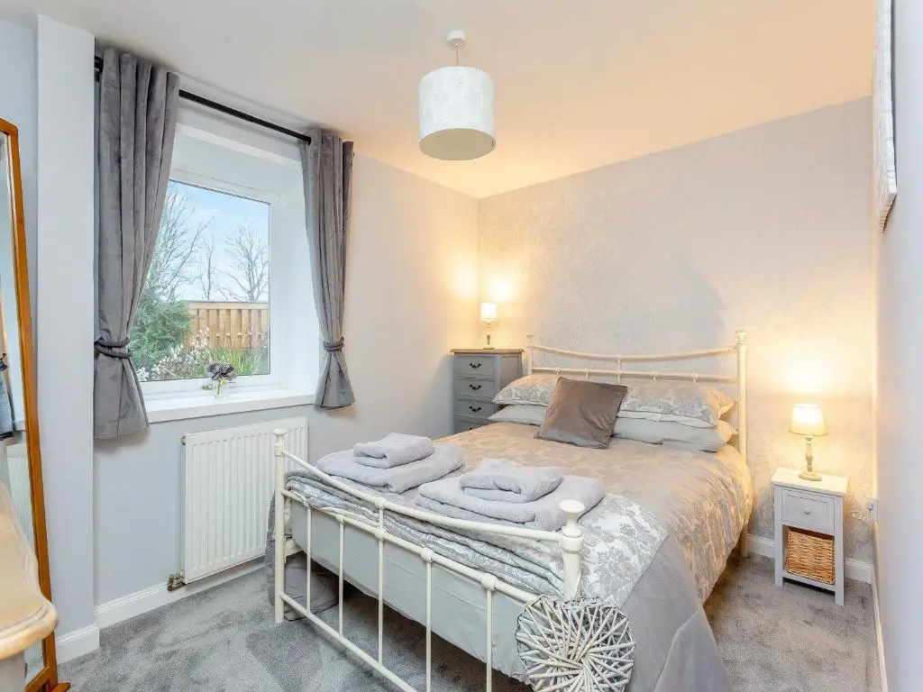 a bedroom with a bed and a window at East Tarrel Cottage in Portmahomack