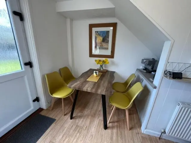 a small room with a table and yellow chairs at Above the harbour wick in Wick