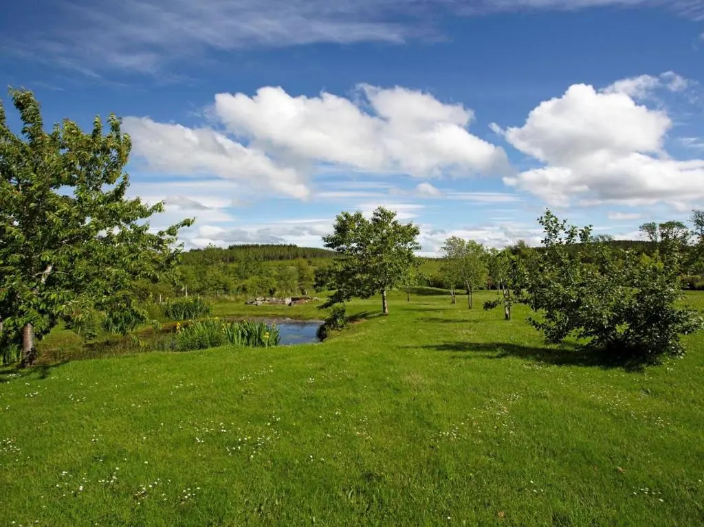 a field of green grass with a river and trees at 2 Bed in Ardross oc-ca384 in Stittenham