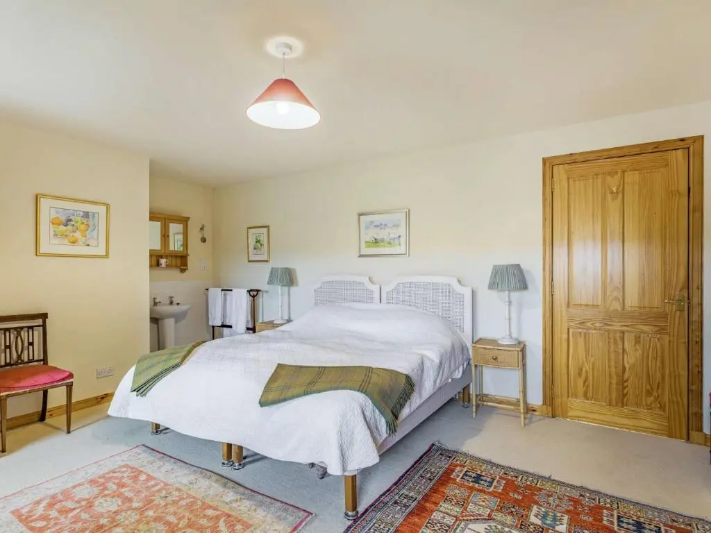 a bedroom with a white bed and a wooden cabinet at 4 Bed in Grantown-on-Spey CA383 in Aitnoch