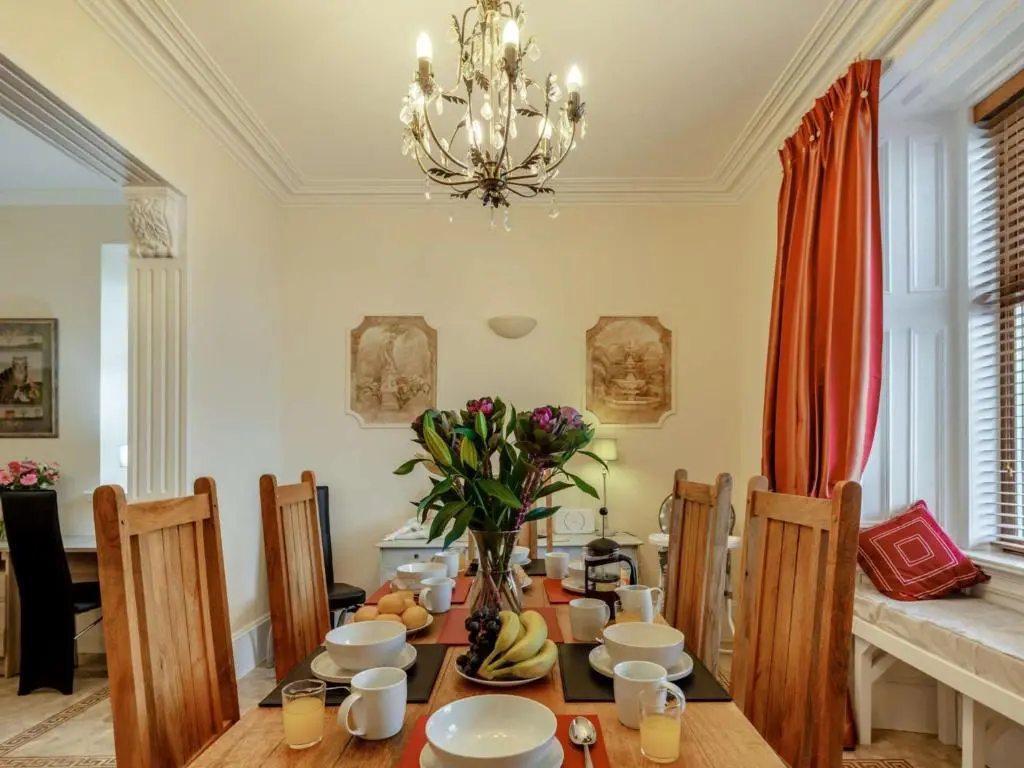 a dining room with a table and a chandelier at 3 Bed in Buckie 89824 in Buckie