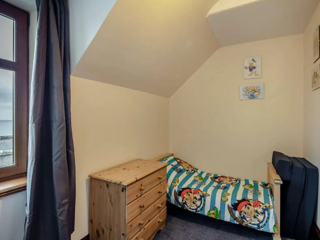 a bedroom with a bed and a dresser and a window at 3 Bed in Buckie 89824 in Buckie