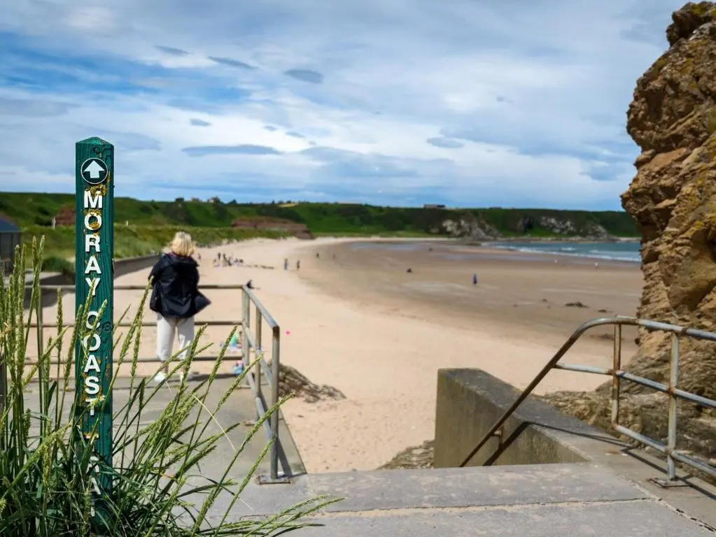 a woman walking down the stairs to the beach at 3 Bed in Buckie 89824 in Buckie