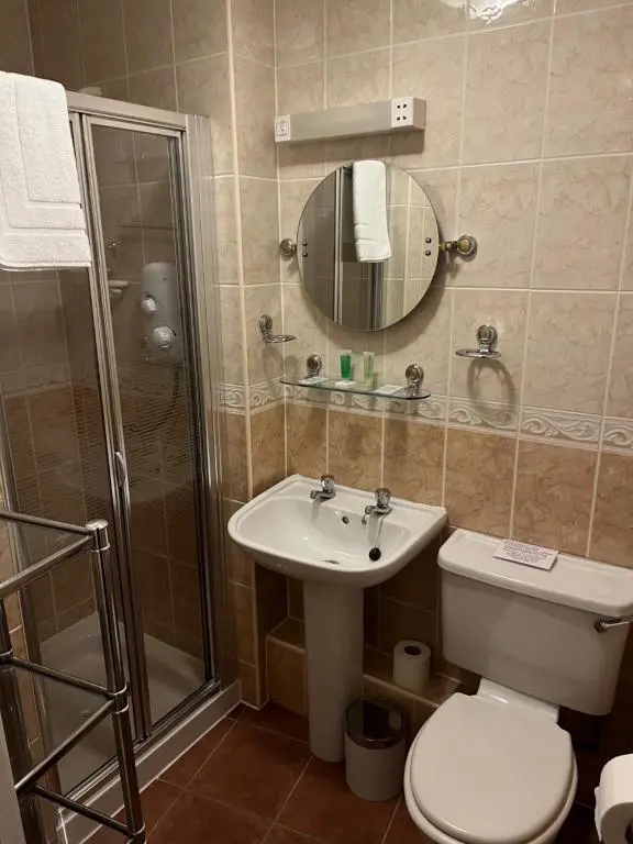 a bathroom with a toilet and a shower and a sink at The Anderson in Fortrose