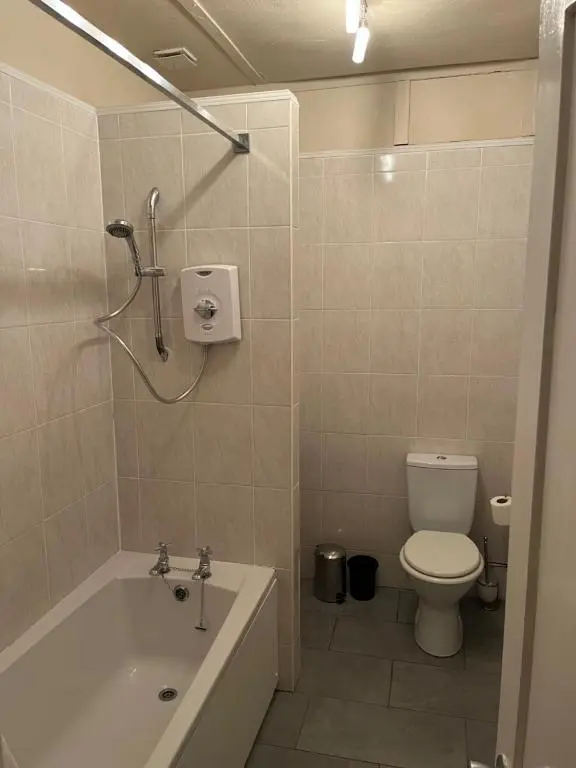 a bathroom with a tub and a toilet and a sink at The Anderson in Fortrose